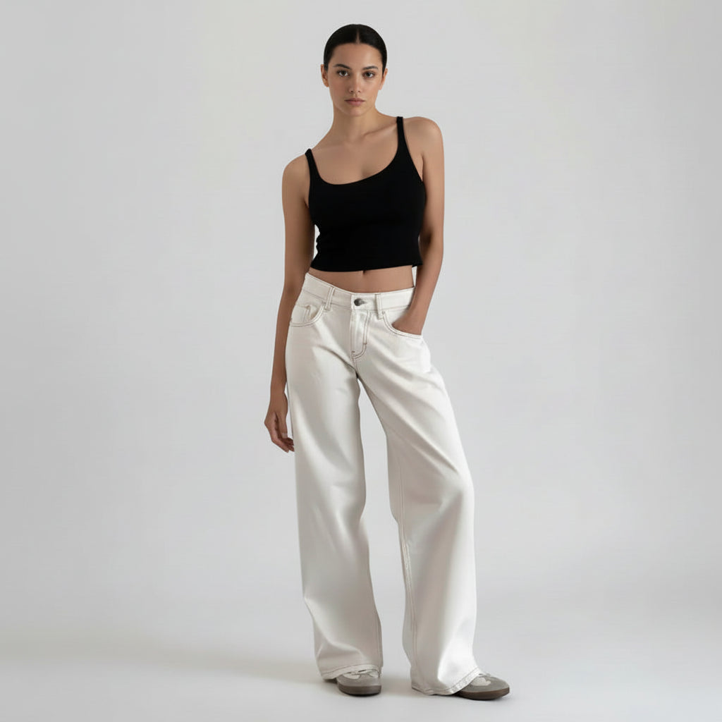 Person wearing white wide-leg jeans and a black top on a white background